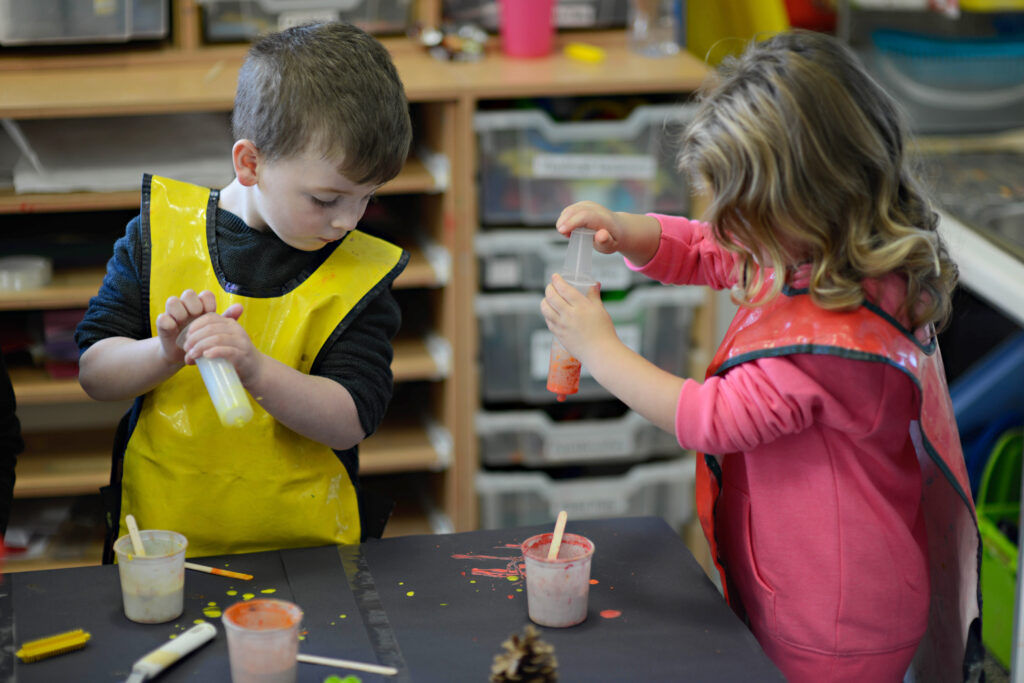 two young children playing with paint and pipettes | Ducklings Nursery